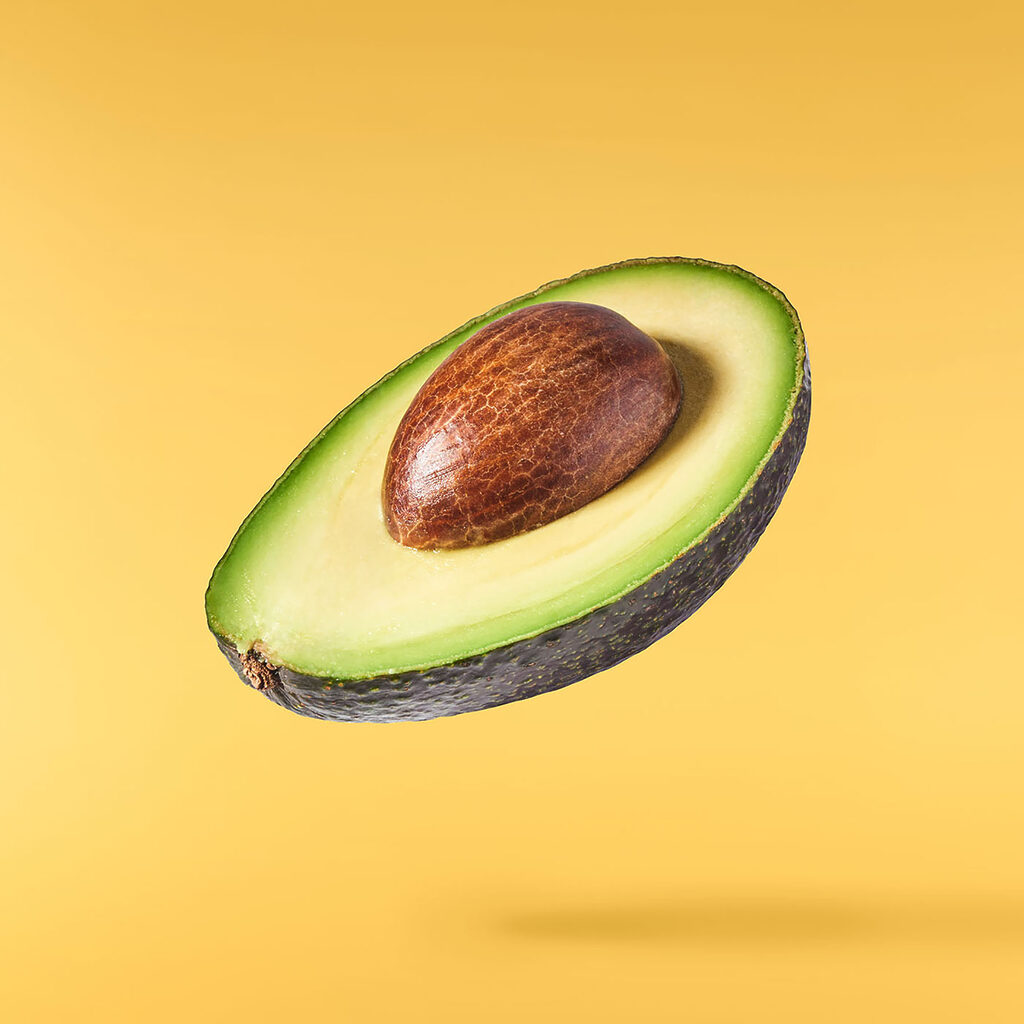 Avocado zweeft op geel — volledig ontwerp